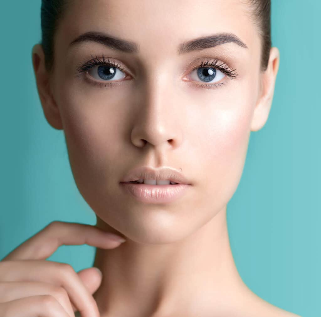 A beautiful brunette woman touching her chin