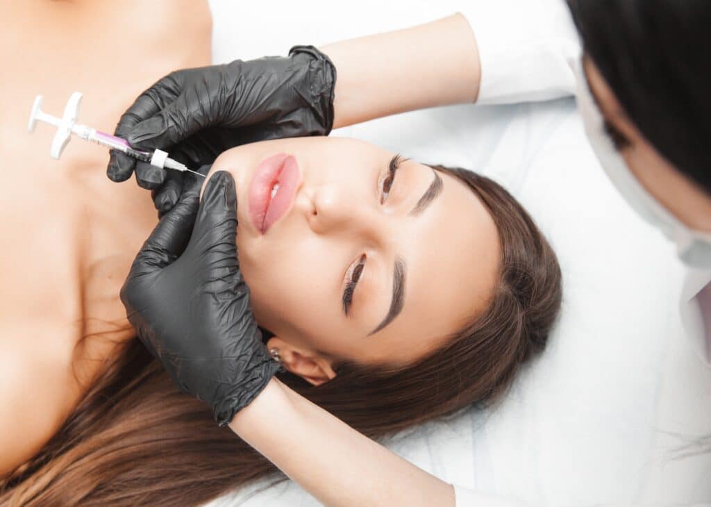 A woman receiving a Kybella injection in her chin.