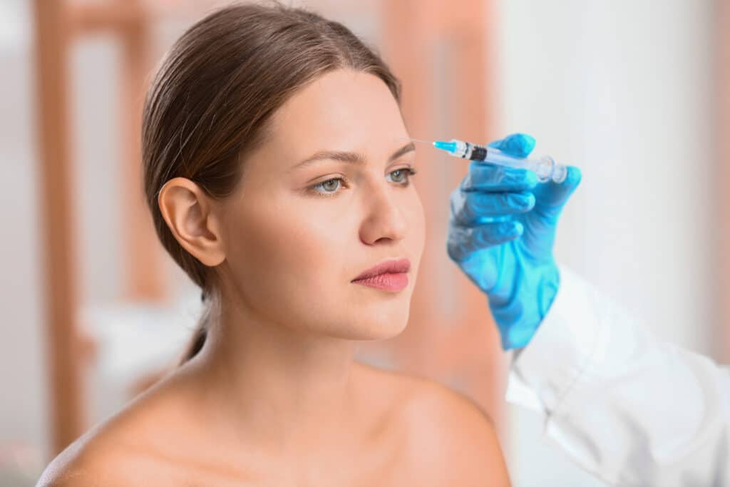 A woman getting a Xeomin injection in her face.